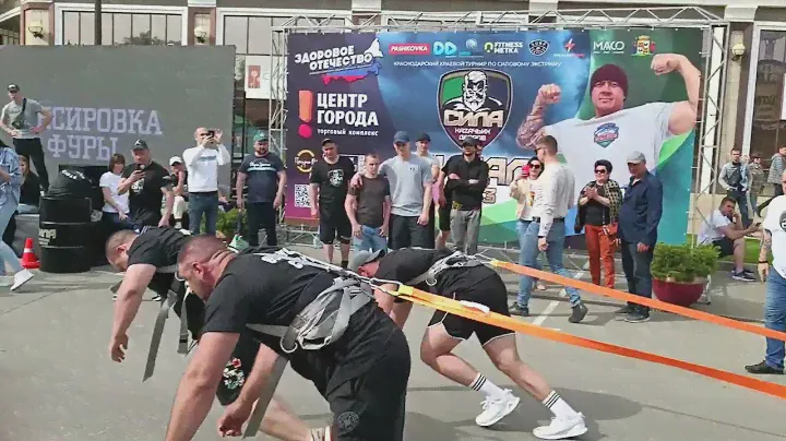 Strong men pull a concrete mixer. Competition in Krasnodar.
